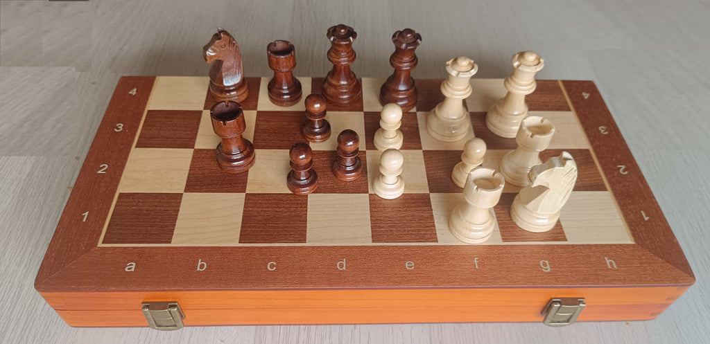 Échiquier en bois avec inscription alphanumérique et fermetures métalliques, pièces d'échecs en position de jeu