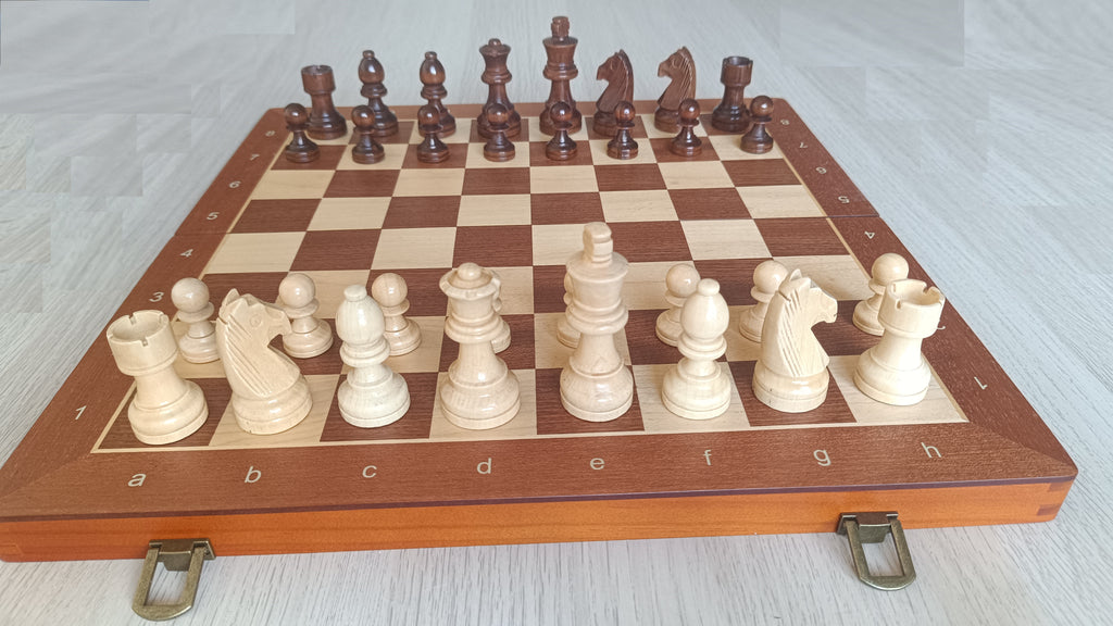 Jeu d'échecs magnétique complet installé sur l'échiquier en bois, vue d'ensemble des deux camps
