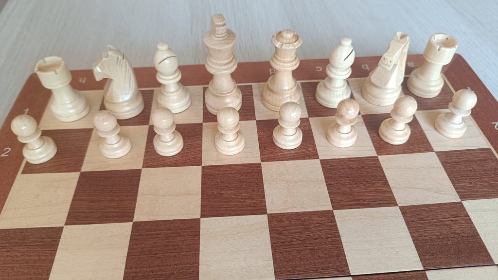 Rangée complète des pièces d'échecs claires aimantées sur l'échiquier en bois