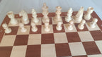 Rangée complète des pièces d'échecs claires aimantées sur l'échiquier en bois