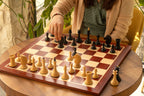 Joueuse déplaçant une figure du jeu d'échecs Queen's Gambit 1957 pendant une partie
