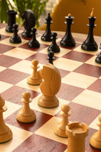 Gros plan sur les figures d'échecs Queen's Gambit 1957 en buis clair sur l'échiquier