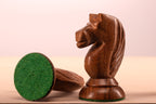 Gros plan sur un cavalier foncé en acacia indien du jeu d'échecs Queen's Gambit 1957 avec sa base feutrine