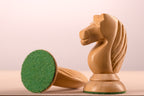 Gros plan sur un cavalier clair en acacia du jeu d'échecs Queen's Gambit 1957 avec sa base feutrine